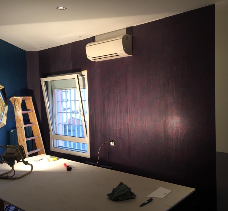 Parete bordeaux con finitura decorativa materica